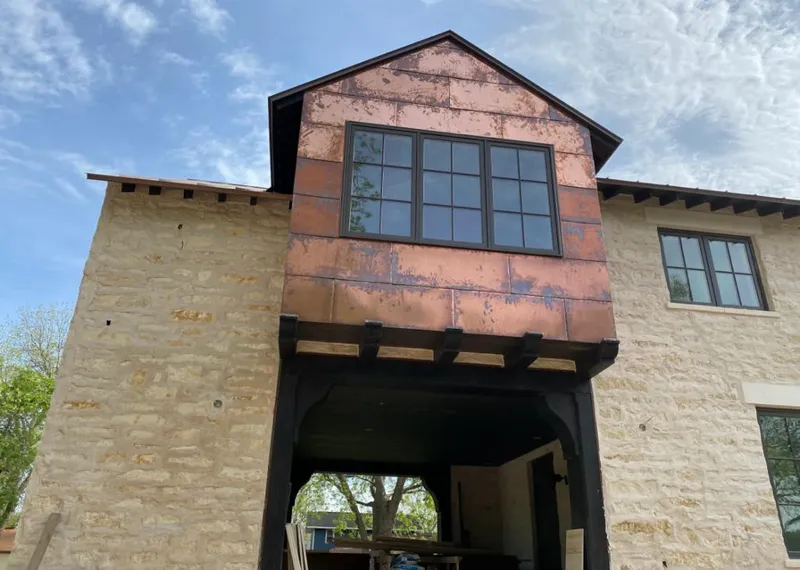 Copper metal panel facade on a stone building for Skylight Installation in Lower Nazareth